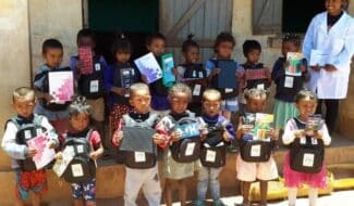 Chères Marraines, Chers Parrains, La période que nous venons de traverser a bouleversé nos vies et celles de millions de personnes à travers le monde, renforçant cette conviction que nous avons également toutes et tous un rôle important à jouer pour aider les enfants à sortir de la précarité. Et lorsque le contexte sanitaire accentue encore plus les disparités, le parrainage permet de mieux les protéger et les accompagner. Merci à vous d’être à nos côtés. A Madagascar, les écoles que nous soutenons ont commencé à rouvrir dès mai, et les activités de nos programmes ont pu progressivement se remettre en route, avec une mobilisation toute particulière des équipes terrain pour répondre à la situation d’urgence sanitaire mondiale. Aujourd’hui, nous sommes heureux de pouvoir vous envoyer des nouvelles de vos filleuls que nous n’avions pu vous transmettre en raison du confinement. Et c’est également l’occasion de vous confirmer la reprise des correspondances avec les enfants par courrier. Merci beaucoup pour votre patience, nous savons à quel point il est important pour vous, comme pour les enfants, de garder le lien, particulièrement depuis ces derniers mois. Grande nouveauté, désormais, les courriers pour votre filleul.e sont à envoyer directement à Madagascar ! Nous vous donnons toutes les indications [au verso de ce courrier]. N’hésitez pas à leur écrire, ils sont tout aussi impatients que vous d’avoir de vos nouvelles ! Il était également important de vous transmettre le bilan des actions 2019 qui ont pu être mises en place, grâce à vous, marraines et parrains, et avec le soutien de nombreux donateurs et entreprises solidaires. Un grand merci pour votre mobilisation et votre engagement qui nous ont permis de répondre aux besoins des enfants et de leur famille en termes d’éducation, de nutrition et de développement agricole, mais aussi de répondre présent et efficacement auprès d’eux depuis la période de crise sanitaire liée à la covid-19. Enfin, nous voulions très sincèrement vous remercier pour les nombreux messages de soutien que vous nous avez adressés, pour les équipes d’ici et sur le terrain, et pour votre constante bienveillance et générosité envers les enfants que vous accompagnez à Madagascar, où il y a encore tant à faire. Si les derniers mois nous ont contraints à garder nos distances les uns des autres, ces formidables élans de solidarité et d’humanité nous ont, d’une certaine manière, tous un peu plus rapprochés. Bien sincèrement,