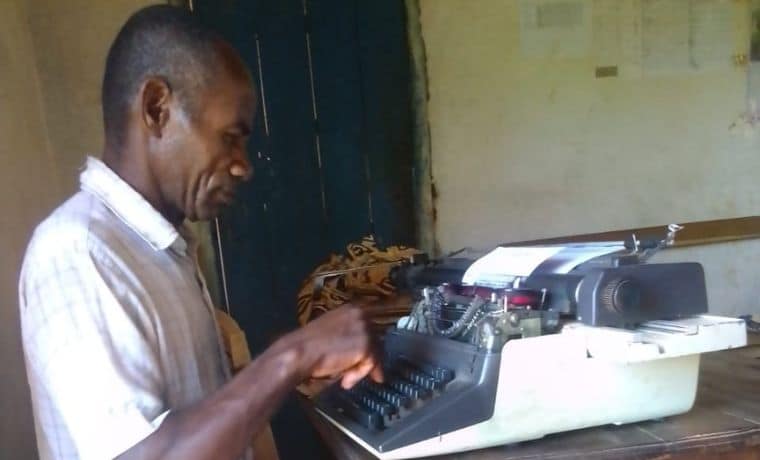 le-secretaire-de-mairie-en-train-de-taper-un-certificat-de-naissance-1